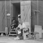 5) The third letter of what the man is sitting in. 6) The third letter of the sign next to the door. Outside of barrack